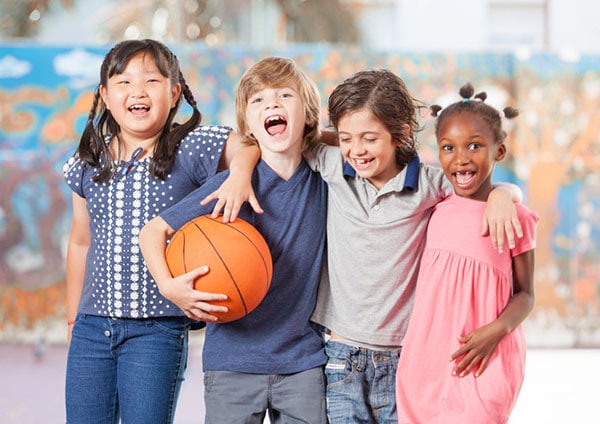 elementary school children happy holding basketball