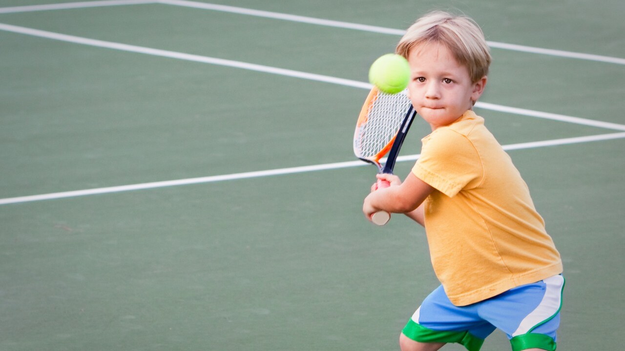Young boy playing Tennis.
