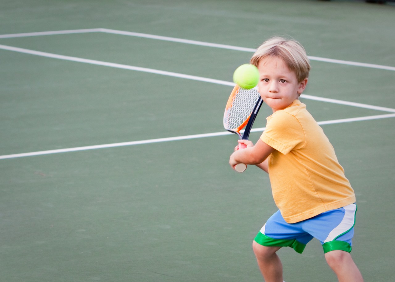 Young boy playing Tennis.