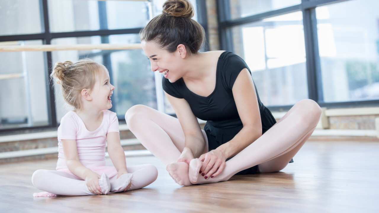Dance teacher and student laughing.