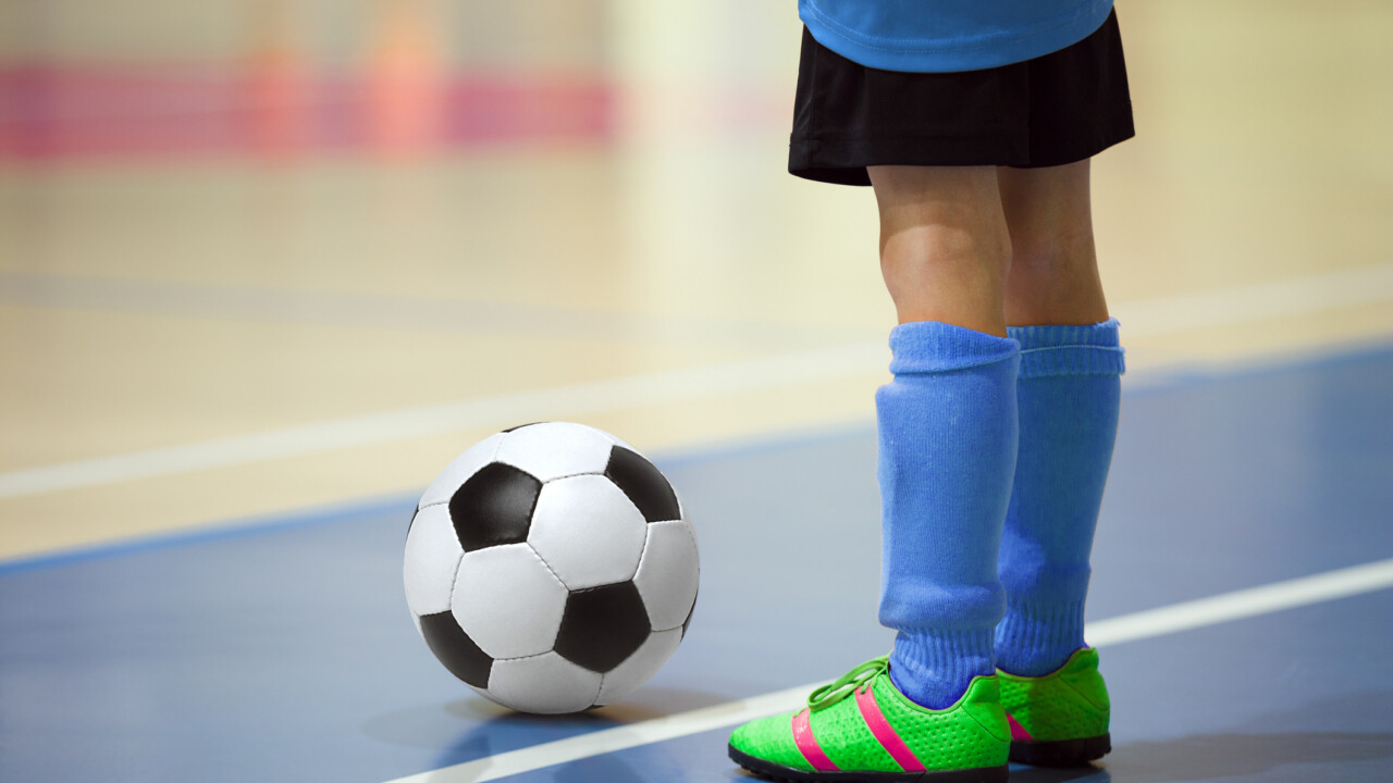 Soccer player getting ready to kick the ball inbounds.